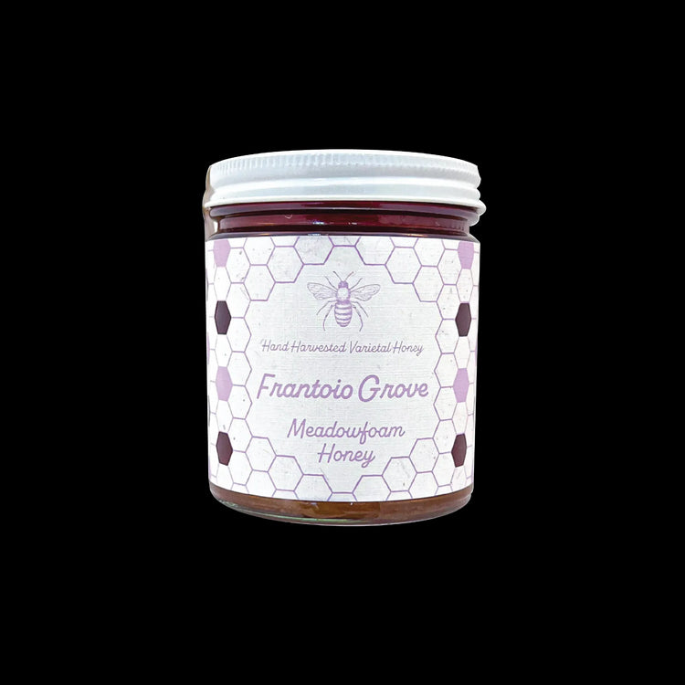 Northwestern Meadowfoam Honey jar with honeycomb pattern label in purple and white, featuring bee logo on glass container