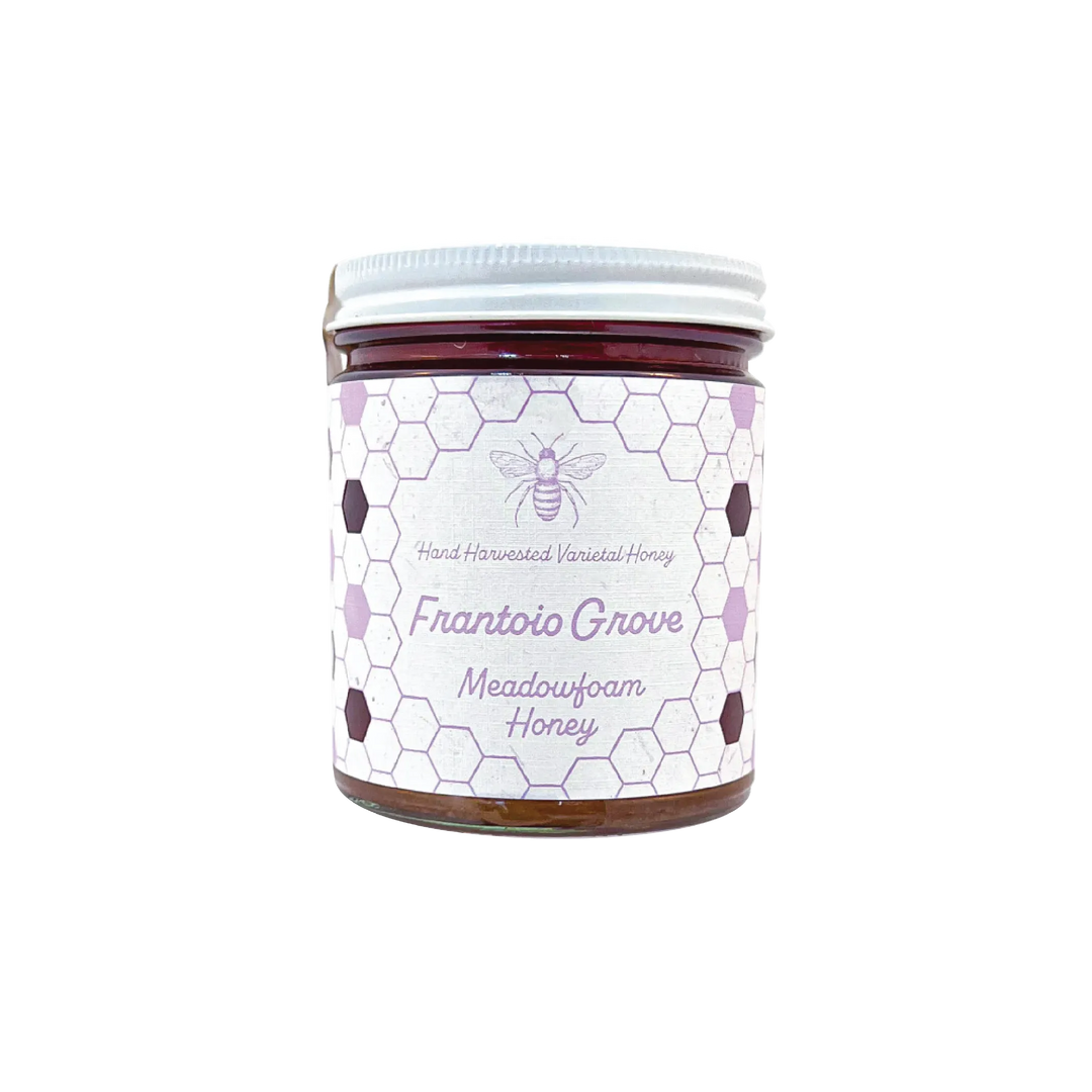 Northwestern Meadowfoam Honey jar with honeycomb pattern label in purple and white, featuring bee logo on glass container