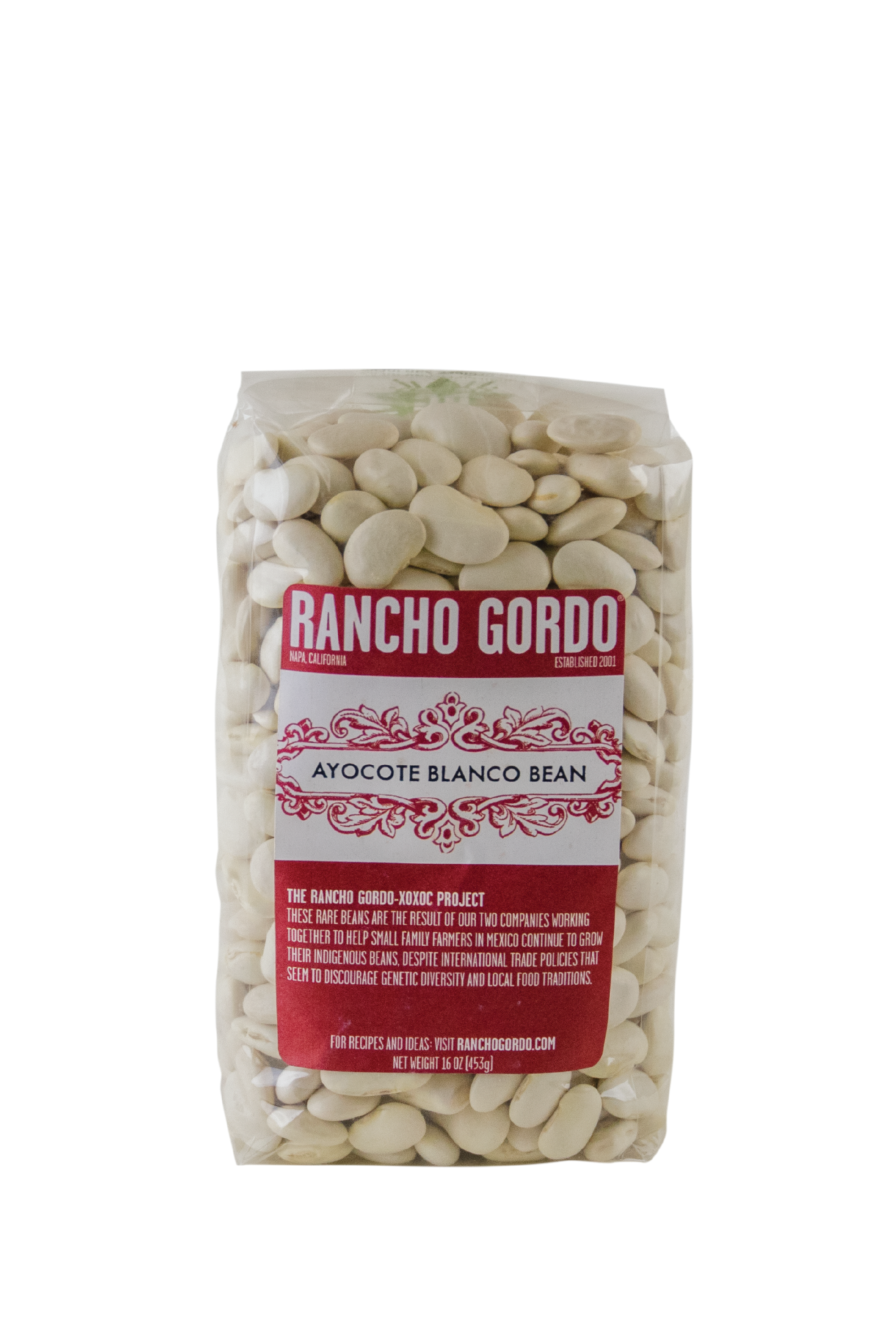 A One Pound Bag of Rancho Gordo Acoyote Morado Beans on a white background. Red and white label. Additional text on bag reads: The Rancho Gordo-Xoxoc Project. These rare beans are the result of our two companies working together to help small family farmers in Mexico continue to grow their indigenous beans, despite international trade policies that seem to discourage genetic diversity & local food traditions.