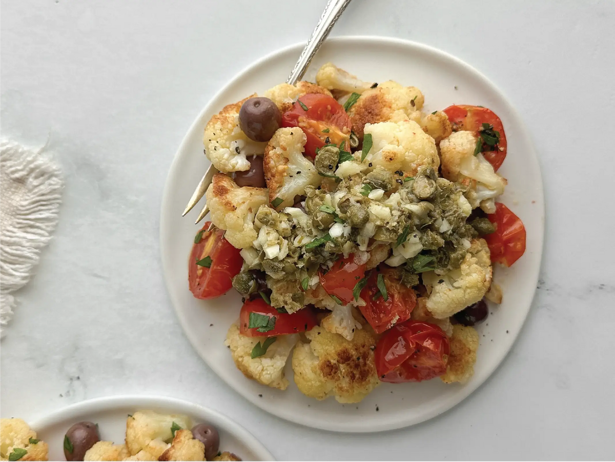 Pan-fried cauliflower with roasted tomatoes, Niçoise olives, and lemon caper sauce