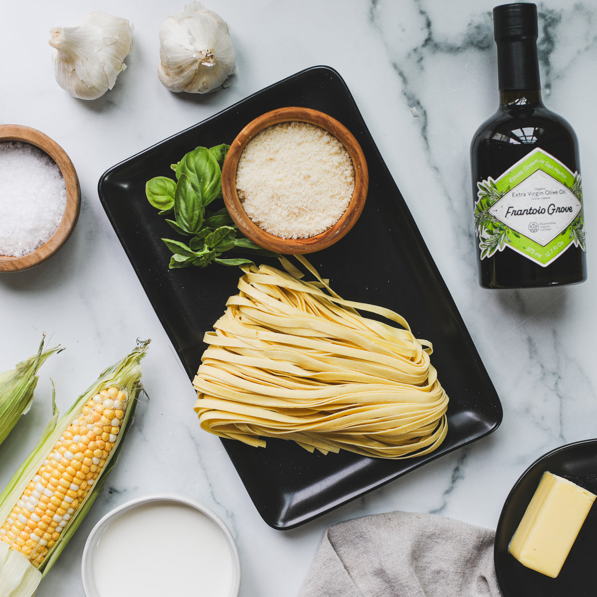Ingredients for corn and basil cream pasta with Frantoio Grove olive oil
