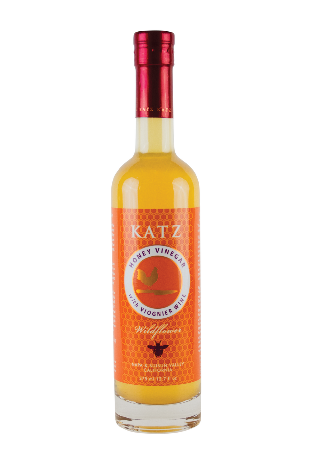 A 375 ml/12.7 oz glass bottle of Katz Honey Vinegar on a white background. Label is orange and white with a pattern of honeycomb. The bottle's logo depicts the shape of a rooster standing on the hilt of a chef's knife in gold with a white, circular border around the picture that says, "Honey Vinegar with Viognier wine." Below the logo is the all black shadow of a bee between the words "Wildflower" and "Napa & Suisun Valley California." Vinegar is a bright, honey yellow color.