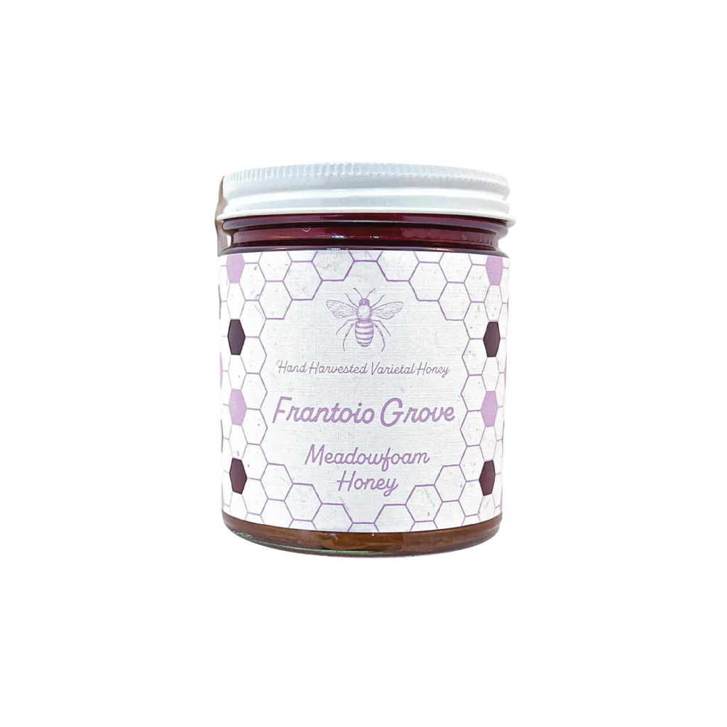 Northwestern Meadowfoam Honey jar with honeycomb pattern label in purple and white, featuring bee logo on glass container