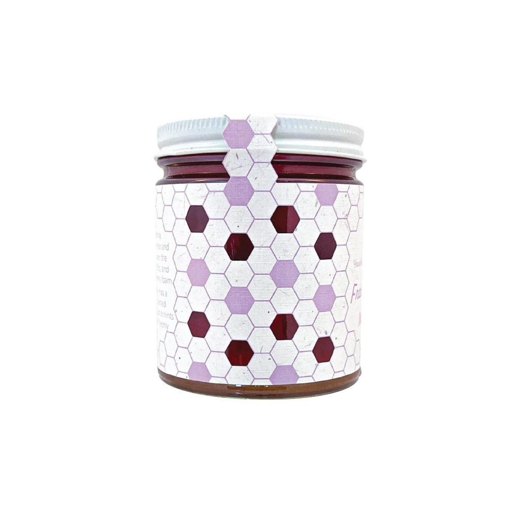 Northwestern Meadowfoam Honey in glass jar with purple and burgundy hexagonal pattern design on white label