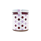 Northwestern Meadowfoam Honey in glass jar with purple and burgundy hexagonal pattern design on white label