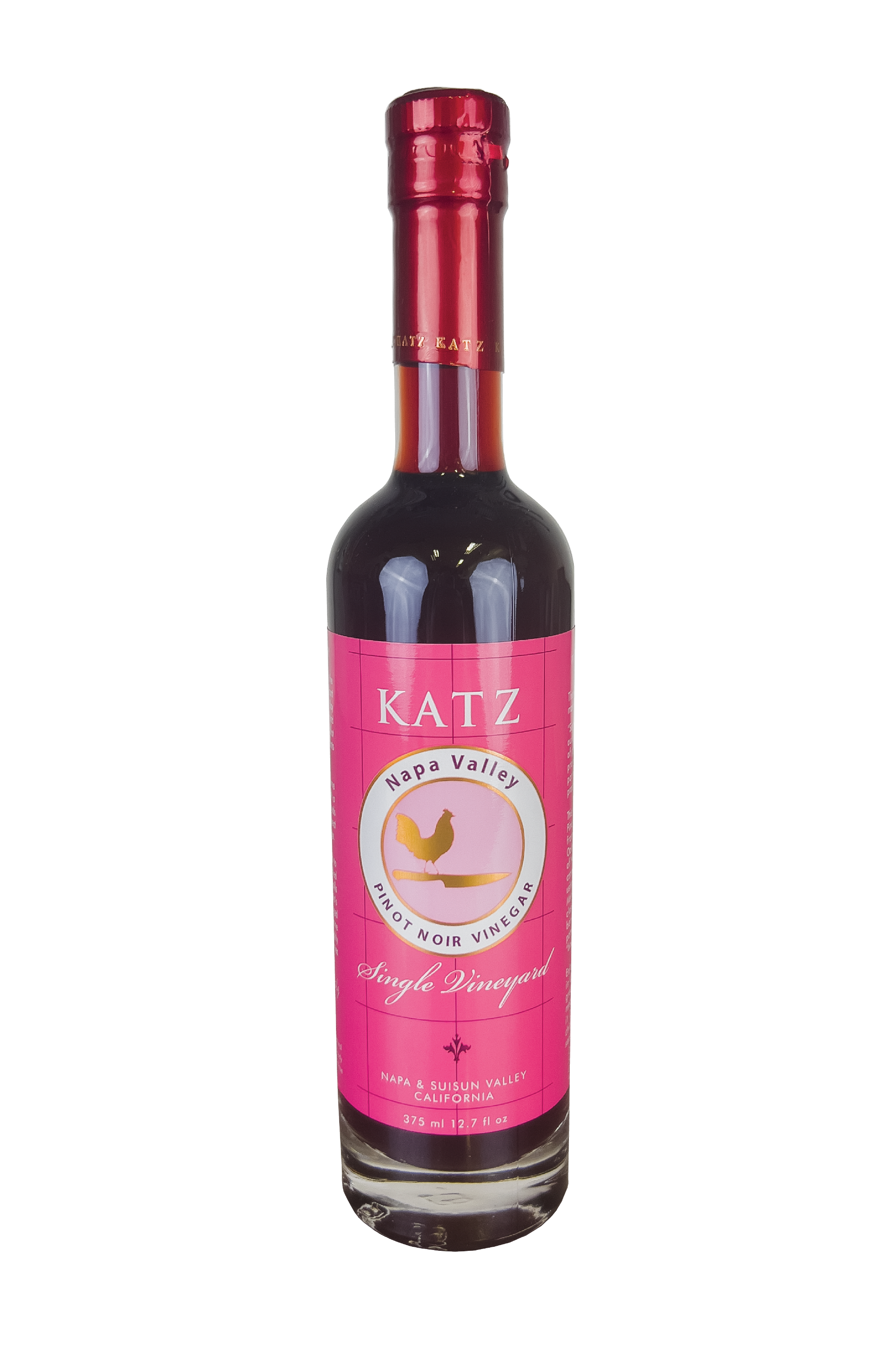 A 375 ml/12.7 oz glass bottle of Katz Pinot Noir Vinegar on a white background. Label is pink and white with a square lattice pattern. The bottle's logo depicts the shape of a rooster standing on the hilt of a chef's knife in gold with a white, circular border around the picture that says, "Napa Valley Pinot Noir Vinegar." Below the logo is small floral motif between the words "Single Vineyard" and "Napa & Suisun Valley California." Vinegar is a rich, dark red color.