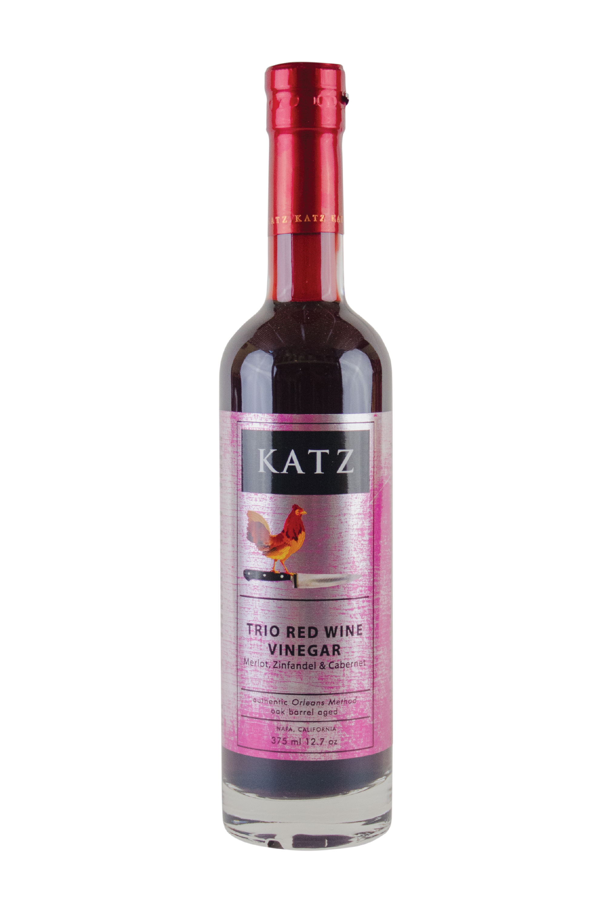 A 375 ml/12.7 oz glass bottle of Katz Trio Red Wine Vinegar (Merlot, Zinfandel & Cabernet) on a white background. Label is metallic white and pink, with a black Katz logo and the image of a rooster standing on the hilt of a chef's knife and the words, "Authentic Orleans Method, oak barrel aged" and "Napa, California" on the bottle. Vinegar is a very dark red, visible through the clear glass bottle with red foil shrink wrap on the top with the word "Katz" printed around the circumference.