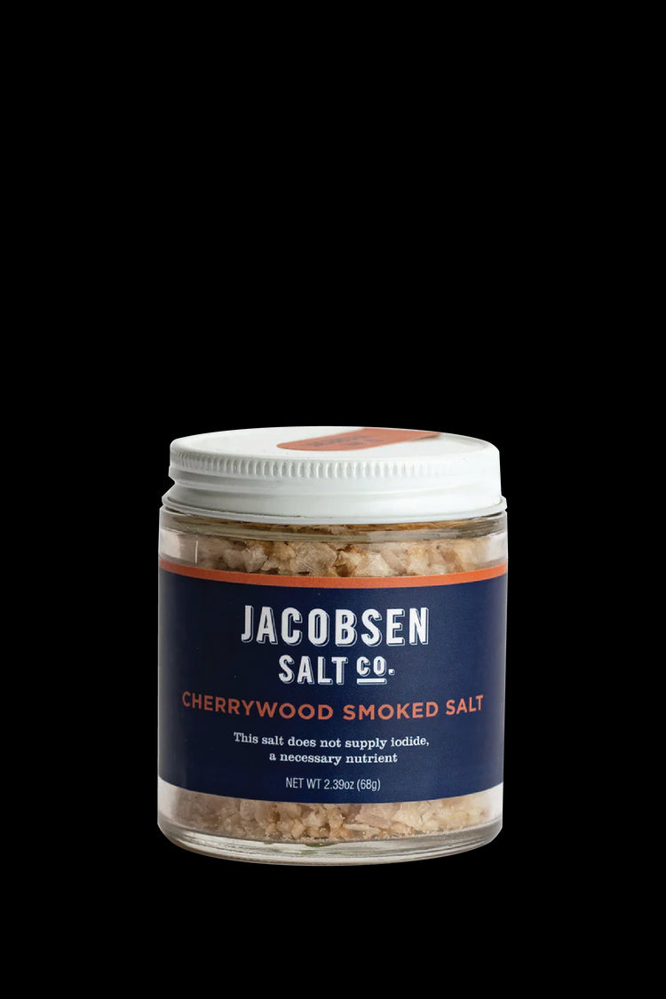 A 2.39 Oz Glass Jar Of Jacobsen Salt Co's Cherrywood Smoked Salt, Featuring a blue label and white lid on a white background